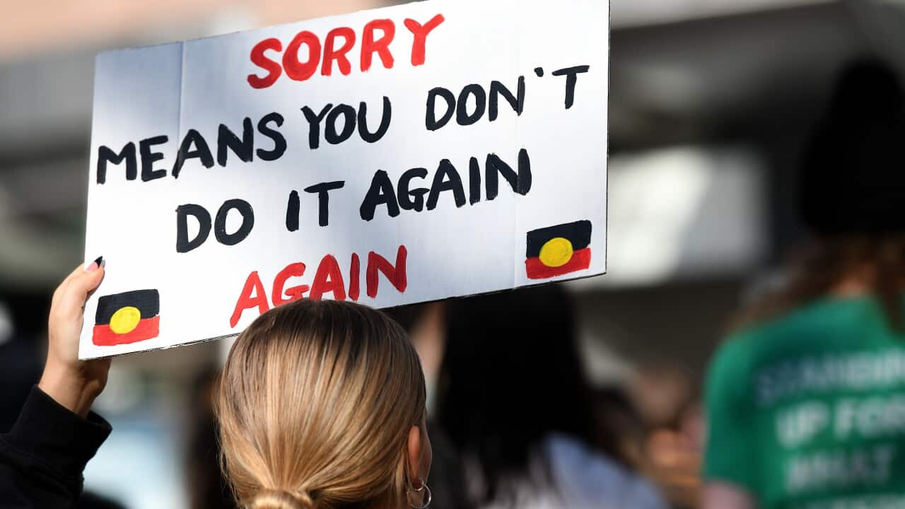 National Sorry Day commemoration with Aboriginal flag and community attendance