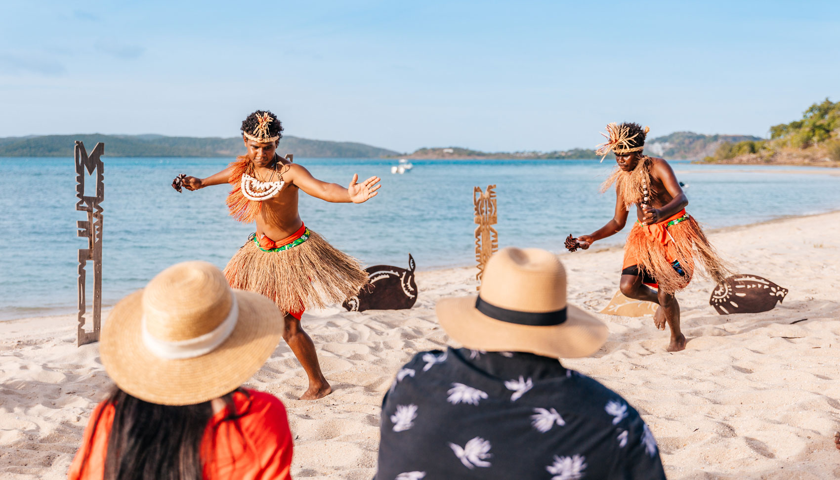 Torres Strait Islander dancers performing on the beach in traditional dress